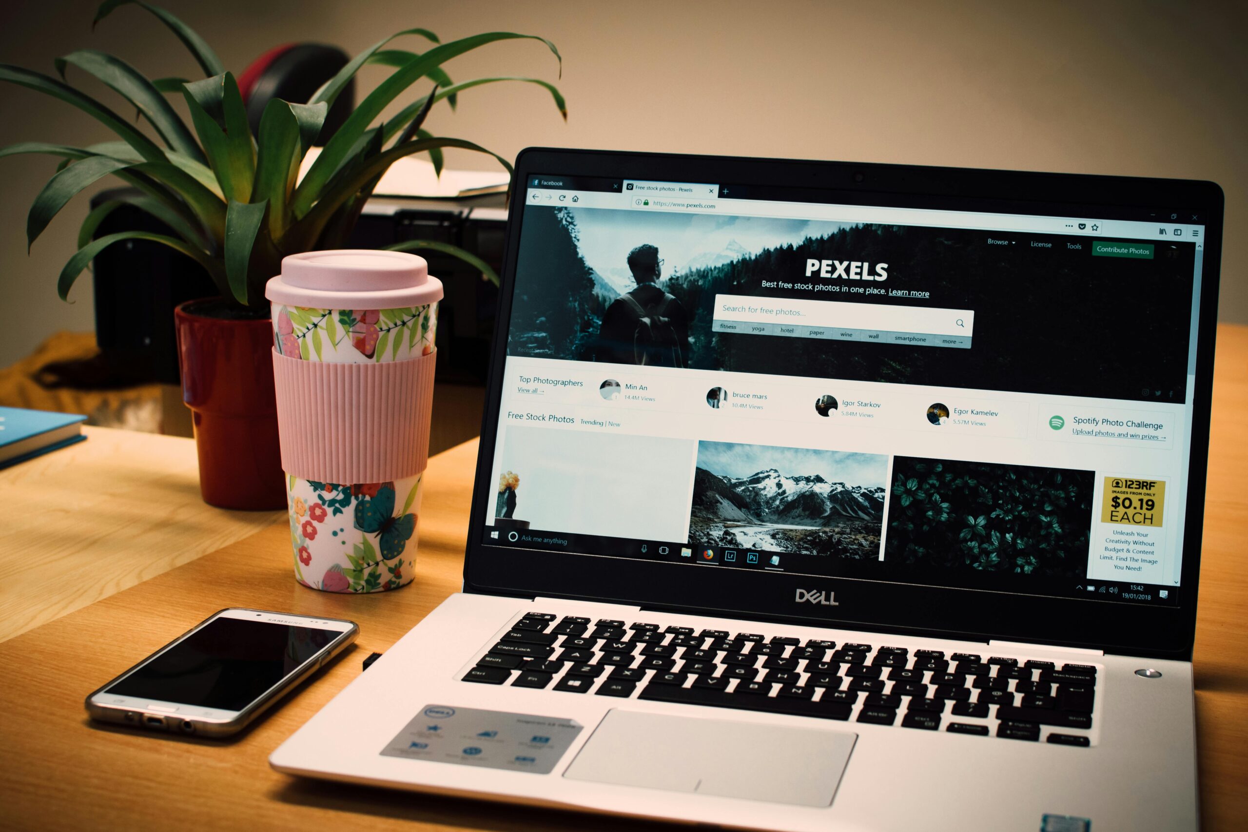 desk with laptop phone and take out coffee